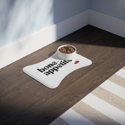 Bone-Appetite pet feeding mat with a bowl of kibble, designed for pets, displayed on a hardwood floor in a modern room.